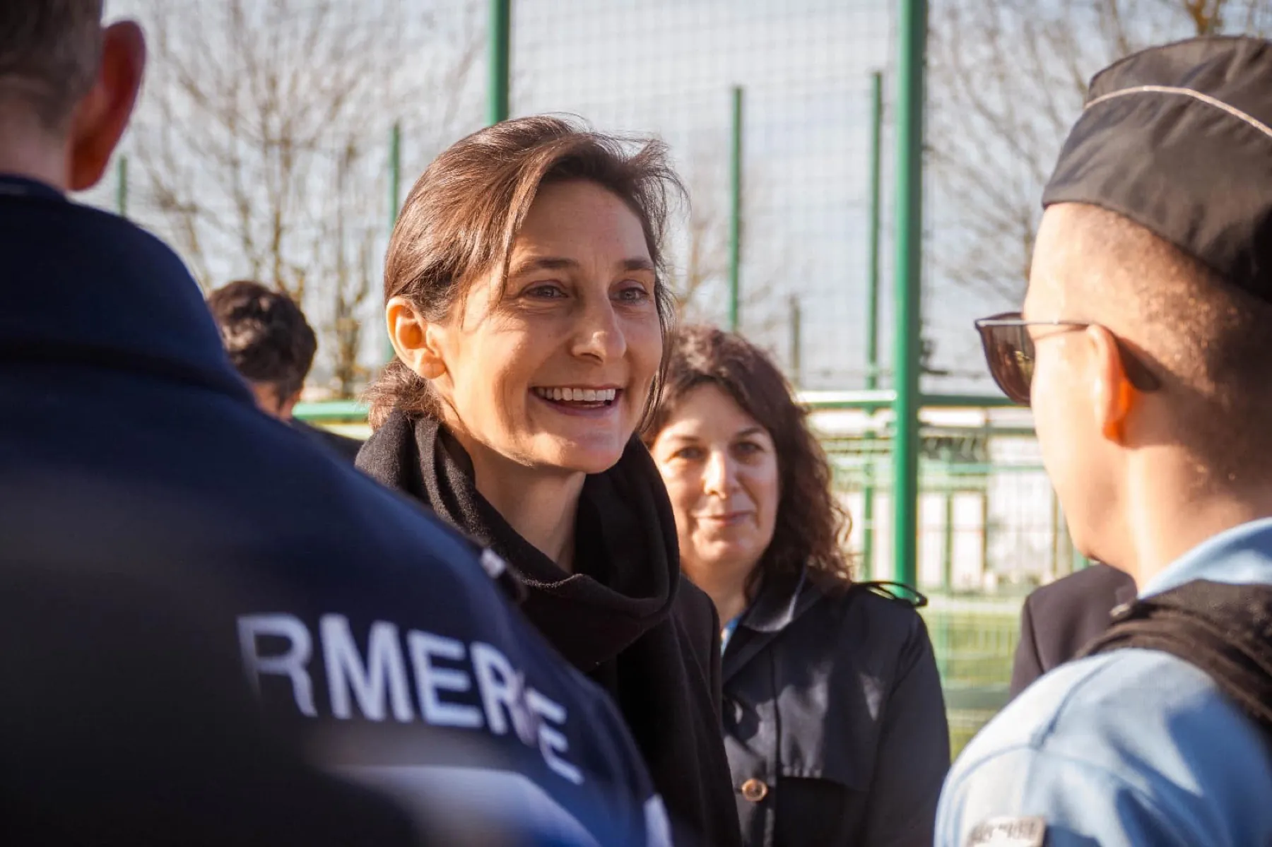 Femme souriante en discussion avec des participants lors d'un événement officiel