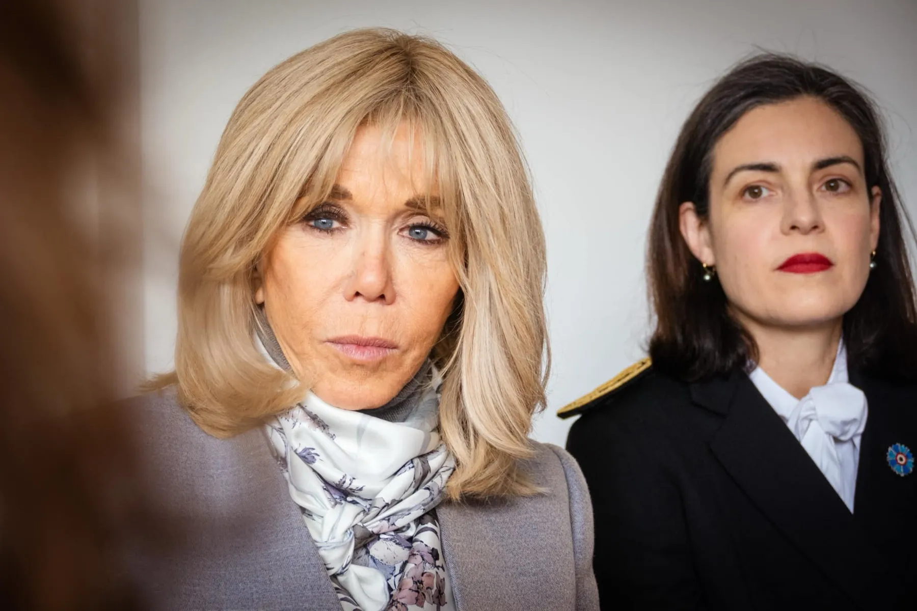 Deux femmes côte à côte, le regard sérieux, lors d'un événement officiel