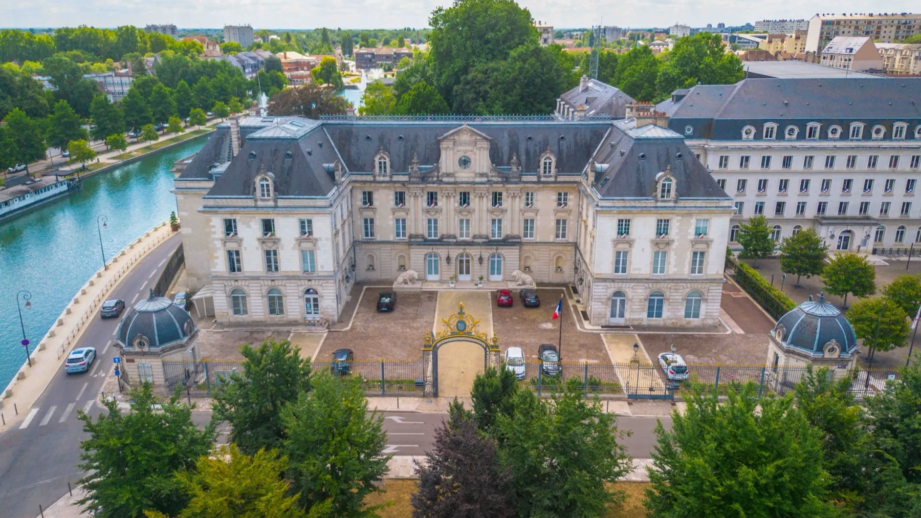 Vue aérienne par drone d'un grand bâtiment classique et de sa cour, au bord d'un canal