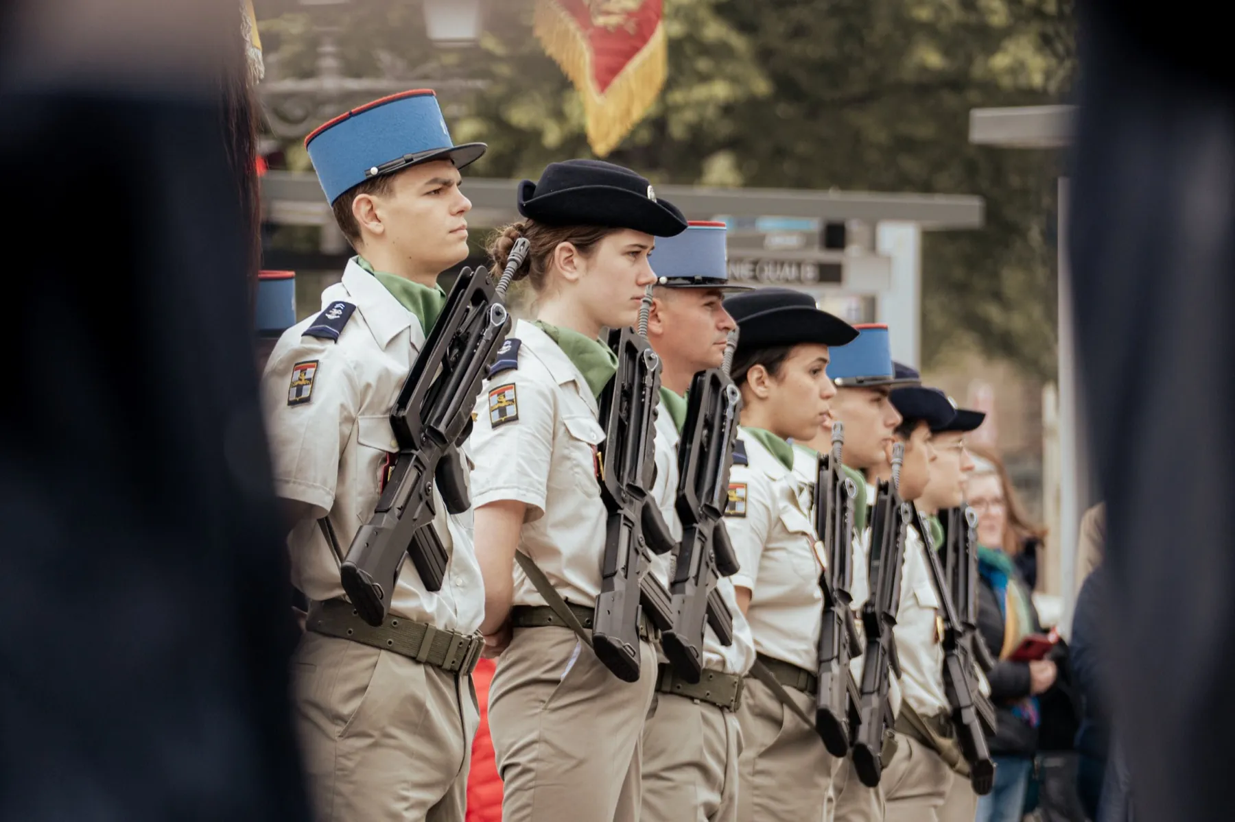 Militaires en tenue de cérémonie alignés avec leurs fusils lors d'une cérémonie
