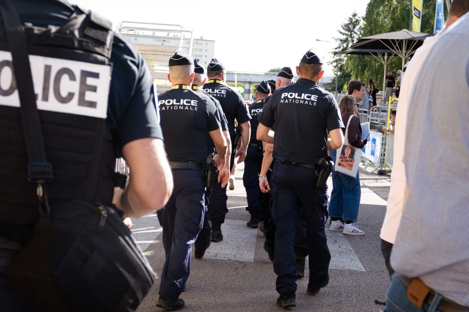 Policiers en uniforme marchant dans une rue lors d'un événement